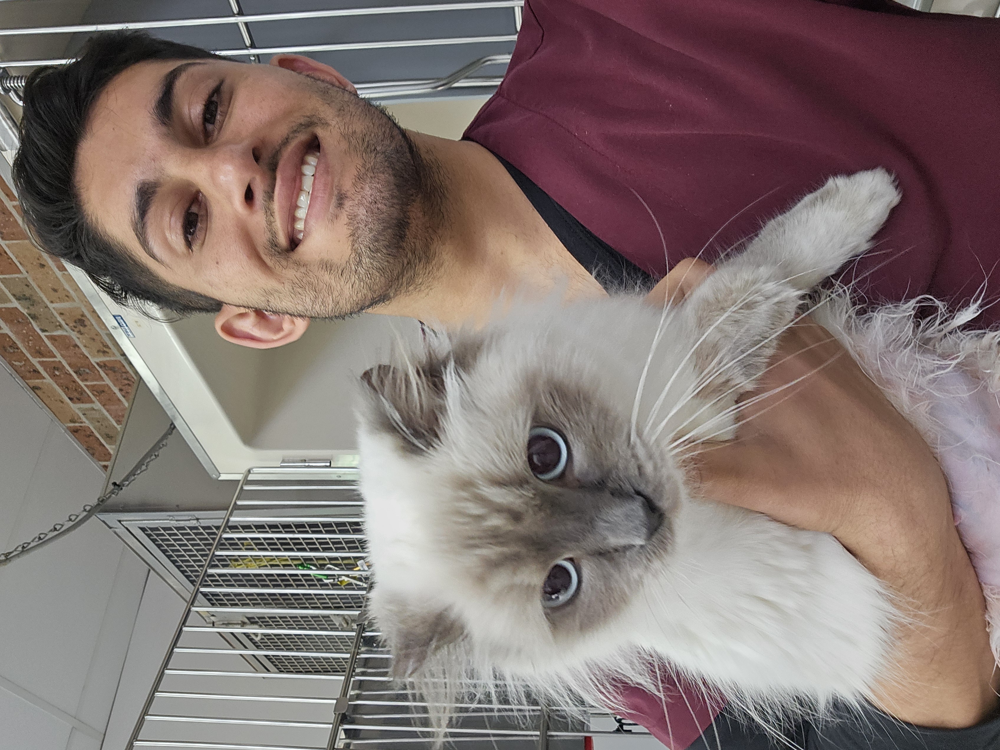 Dr Uzair Carrim smiling while holding a fluffy ragdoll cat